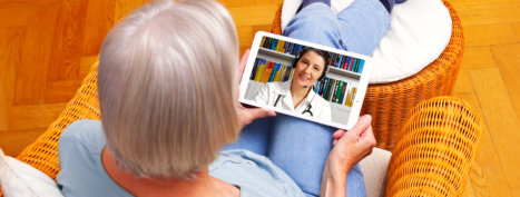 elderly woman talking to a doctor via tablet device