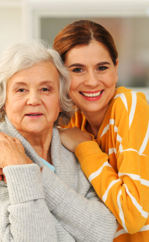 aide and elderly woman smiling