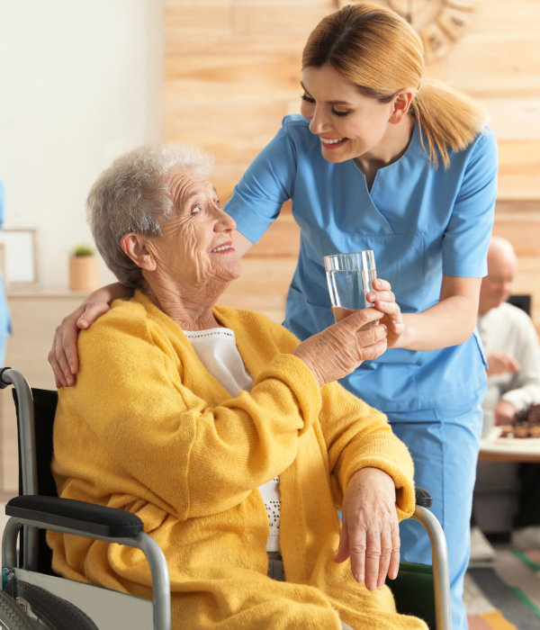 aide and elderly woman smiling at each other