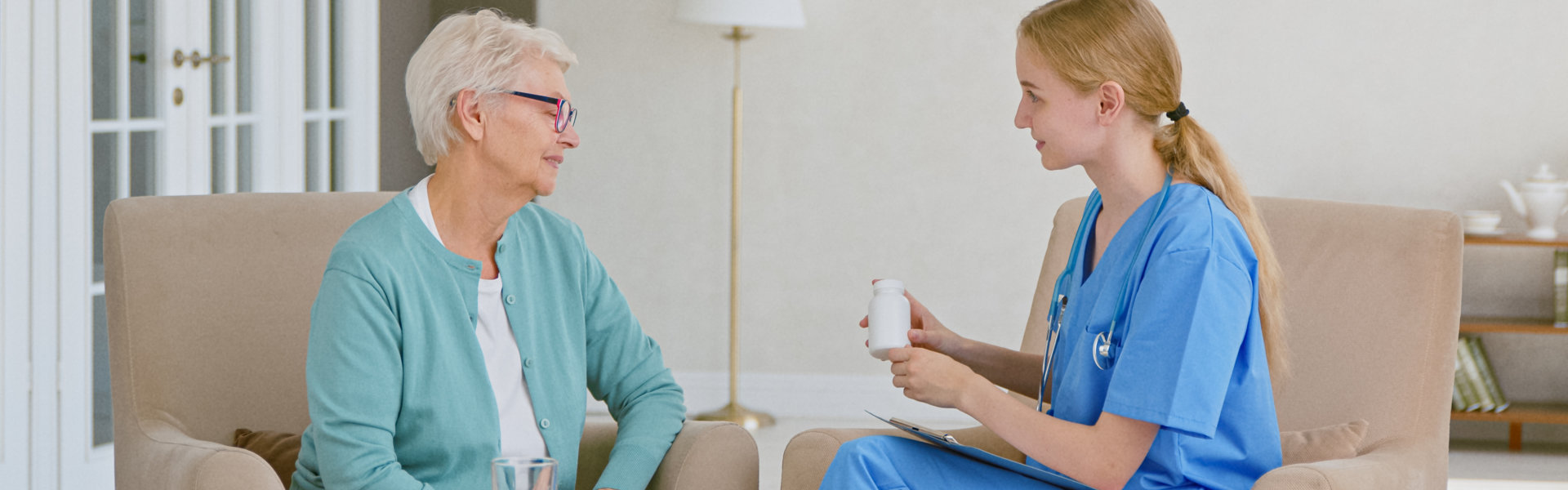 caregiver shows bottle of medicine to elderly woman