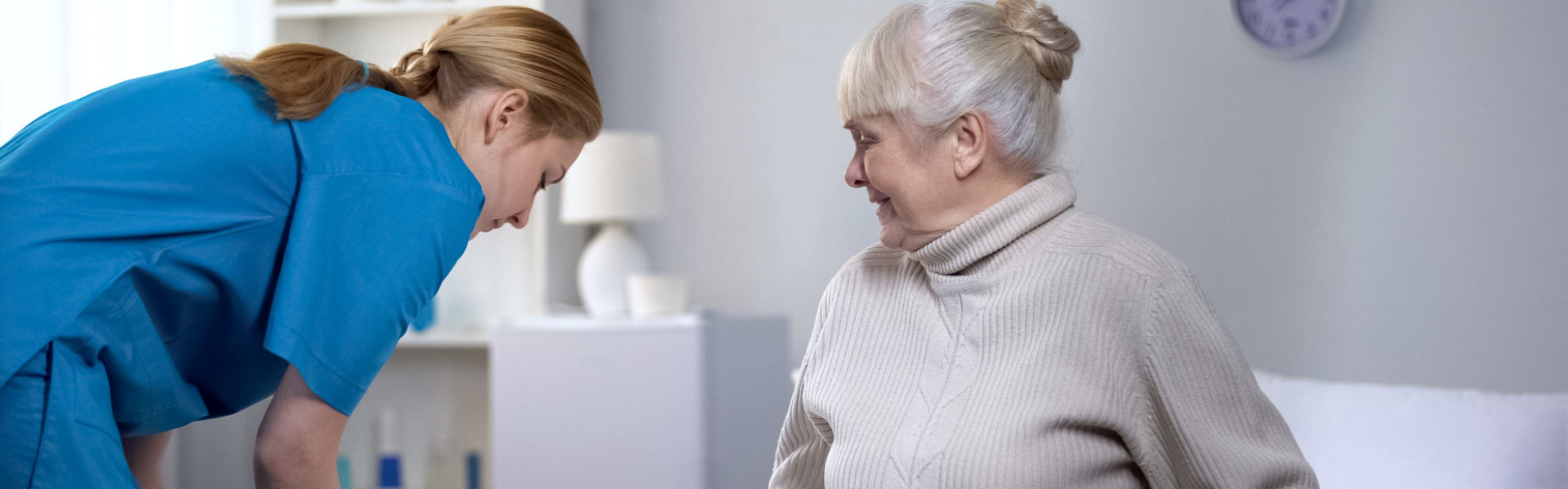 aide assisting an elderly woman